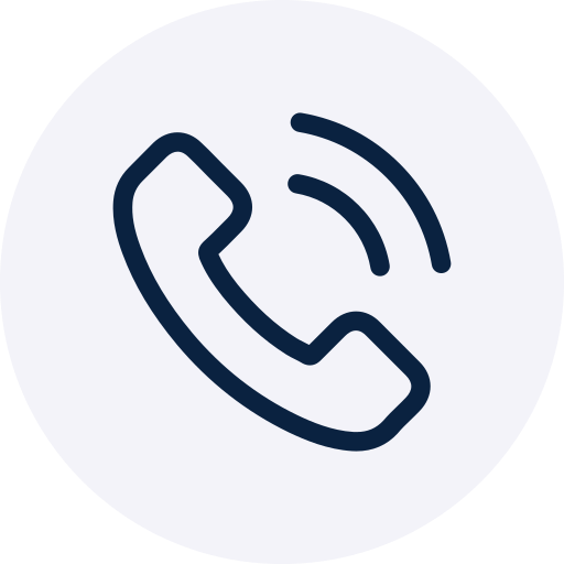 A minimalist icon featuring a dark navy blue telephone handset with two curved lines indicating a ringing phone. The design is centered within a soft, light grey circular background.