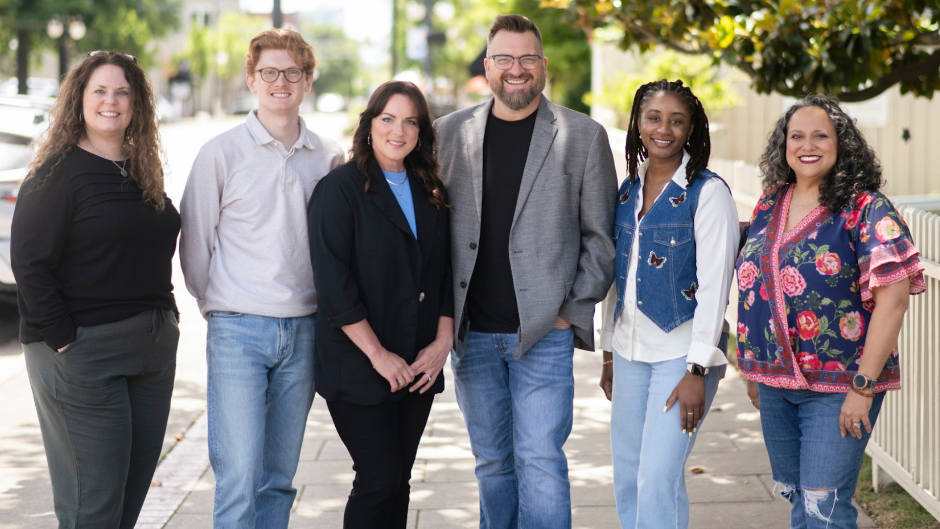 A team of counseling professionals stands together outdoors, smiling and posing in a welcoming community setting. The image highlights a diverse, approachable group dedicated to providing compassionate mental health, counseling, and wellness services.